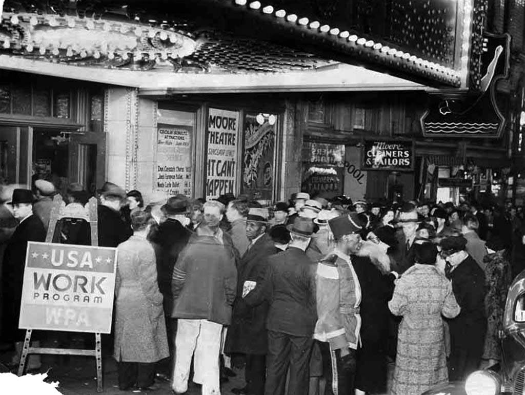 A black and white photo of a Depression-era crowd outside of a theater