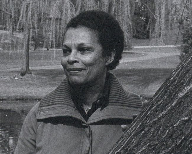 Gwendolyn Knight Lawrence stands beside a tree in a park