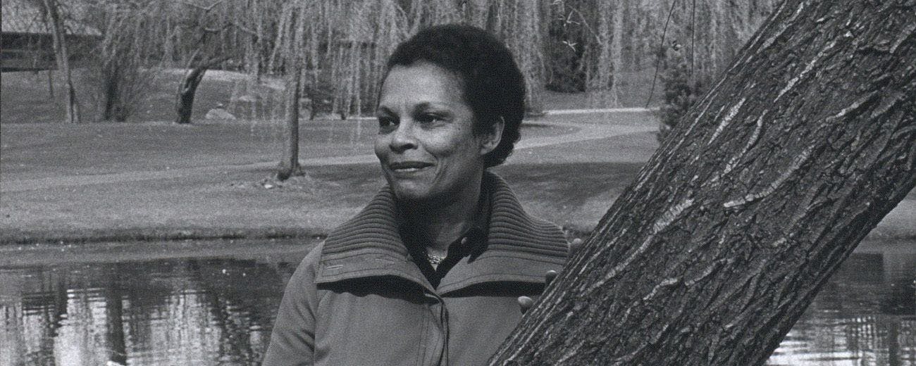 Gwendolyn Knight Lawrence stands beside a tree in a park